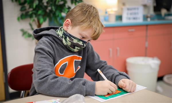 Boy works on paper kite